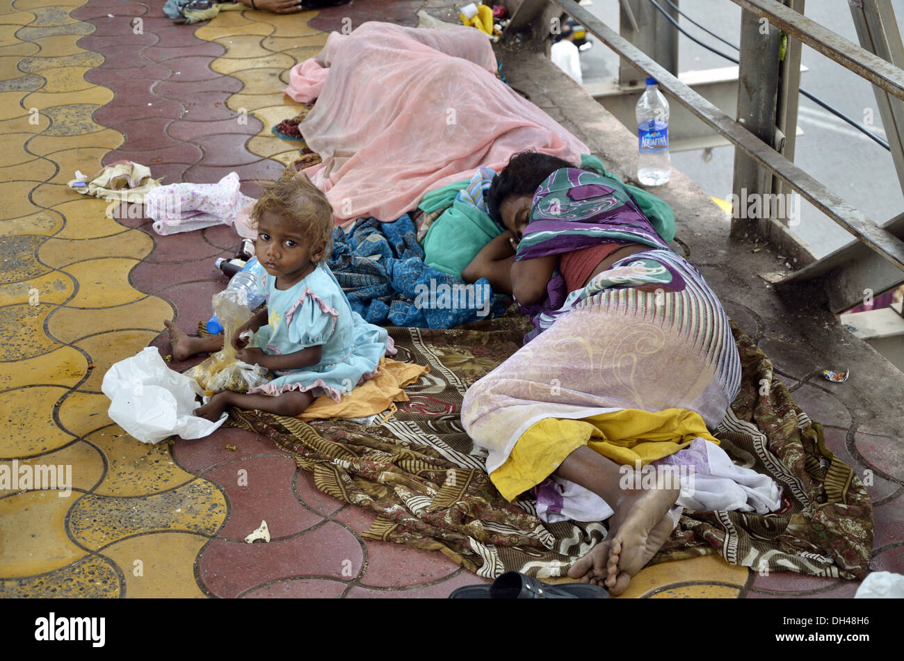 family woman baby child sleeping on pavement footpath Mumbai Maharashtra India Stock Photo