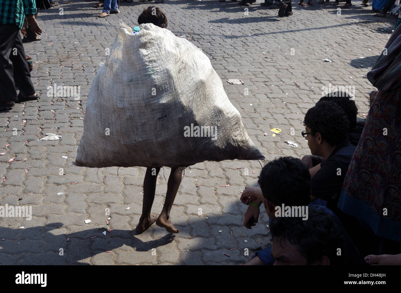 rag waste picker boy with heavy bag on road Mumbai Maharashtra India