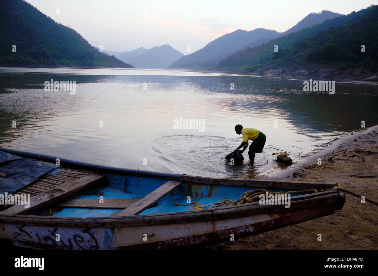 man filling water in bucket from Godavari river at Papi Hills Rajahmundry Andhra Pradesh India Stock Photo