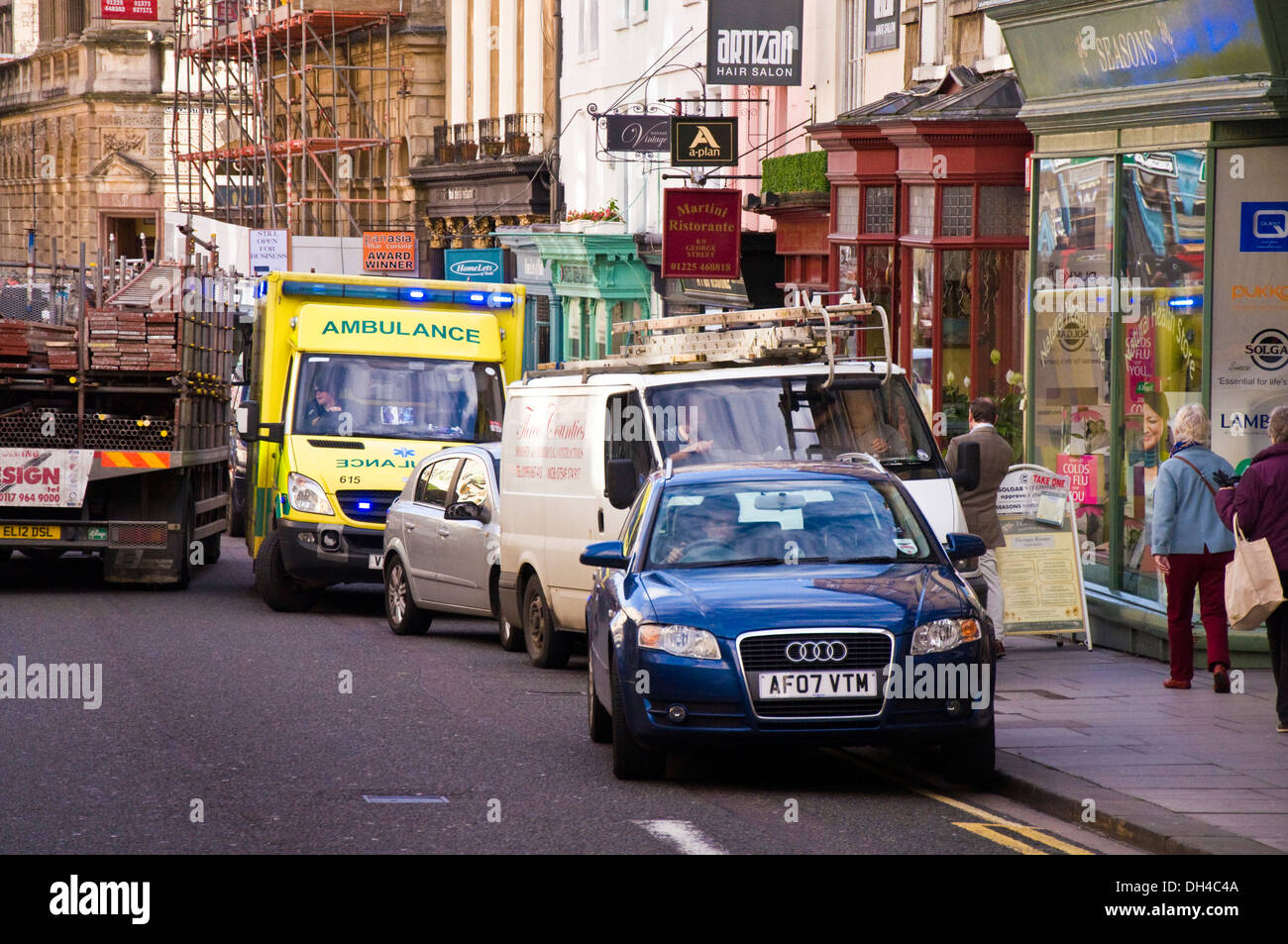 Ambulance on emergency call trying to squeeze through congested traffic on a busy street in Bath Somerset England UK Stock Photo