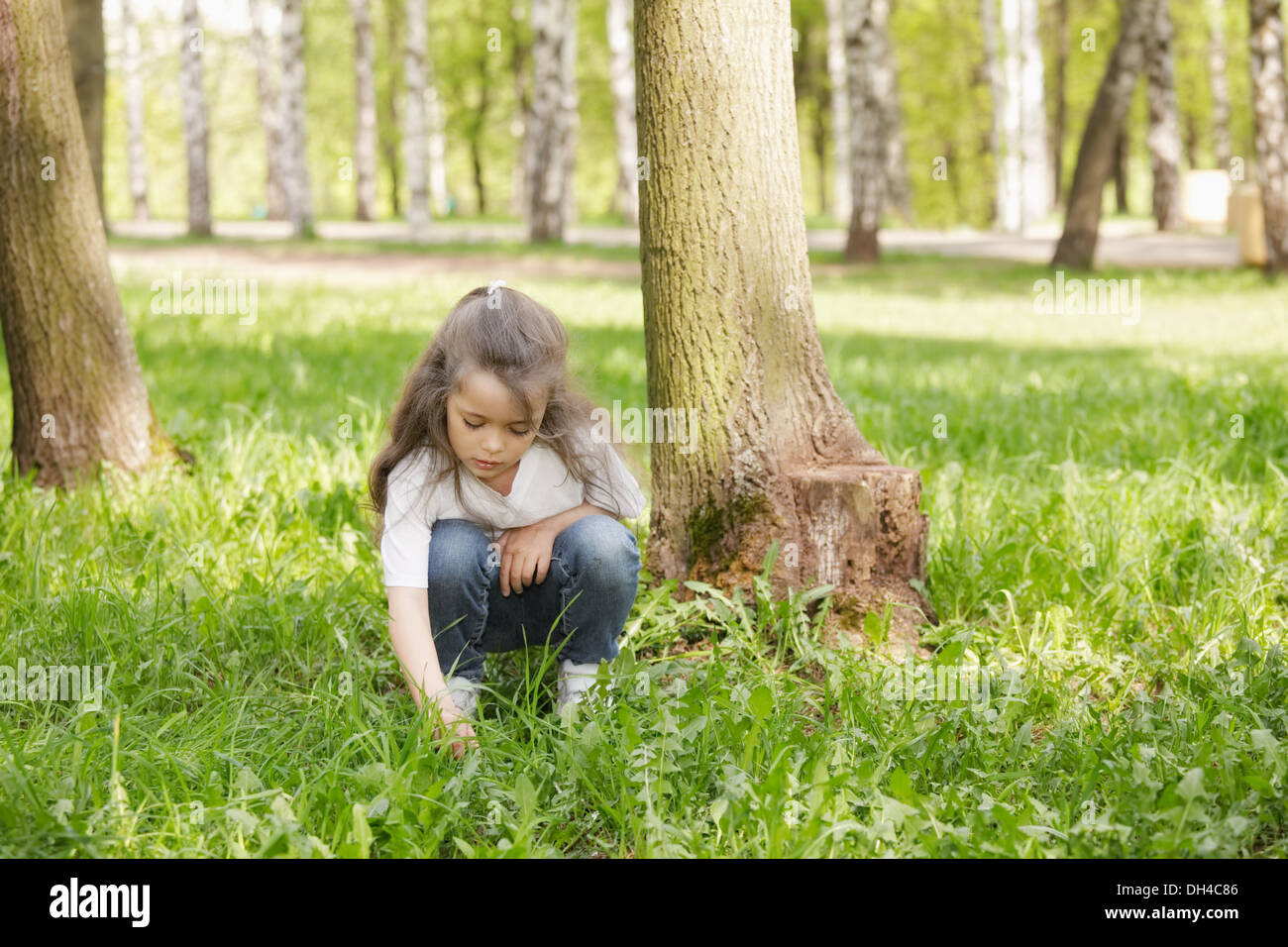Girl playing in grass Stock Photo - Alamy