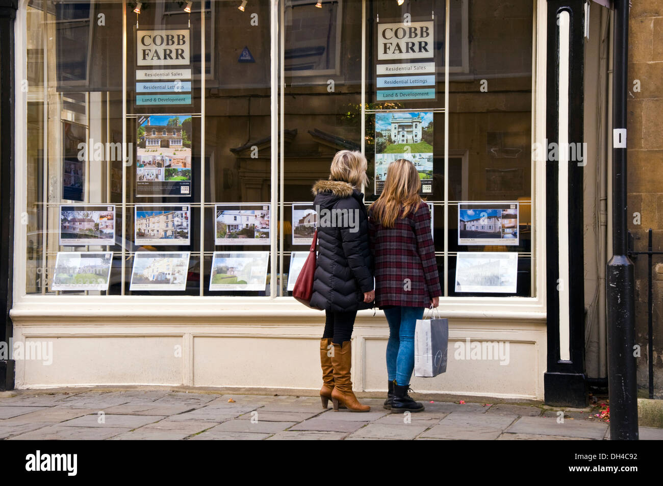 Two women look into an estate agents window in Bath Somerset England UK Stock Photo
