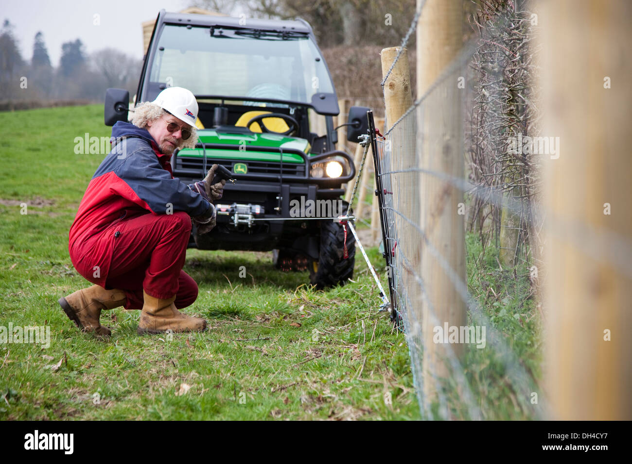 A farmer uses the winch on a John Deere Gator to tension some fencing UK Stock Photo Alamy