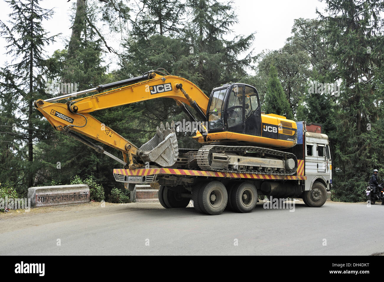 Truck carrying loaded with JCB crane Ranikhet Almora Uttarakhand India Asia Stock Photo