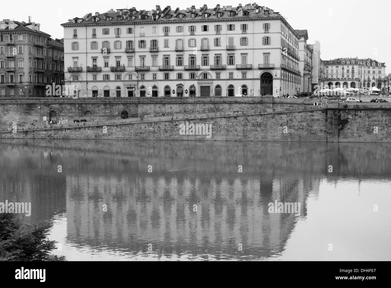 Looking across to a building on Lungo Po Armando Diaz with reflections in the Po River, Torino, Italy. Stock Photo