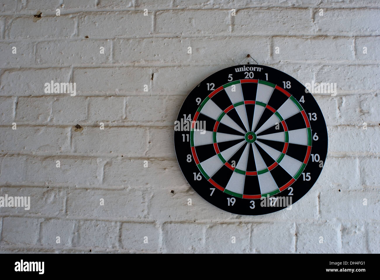 Dartboard on a white brick wall Stock Photo Alamy