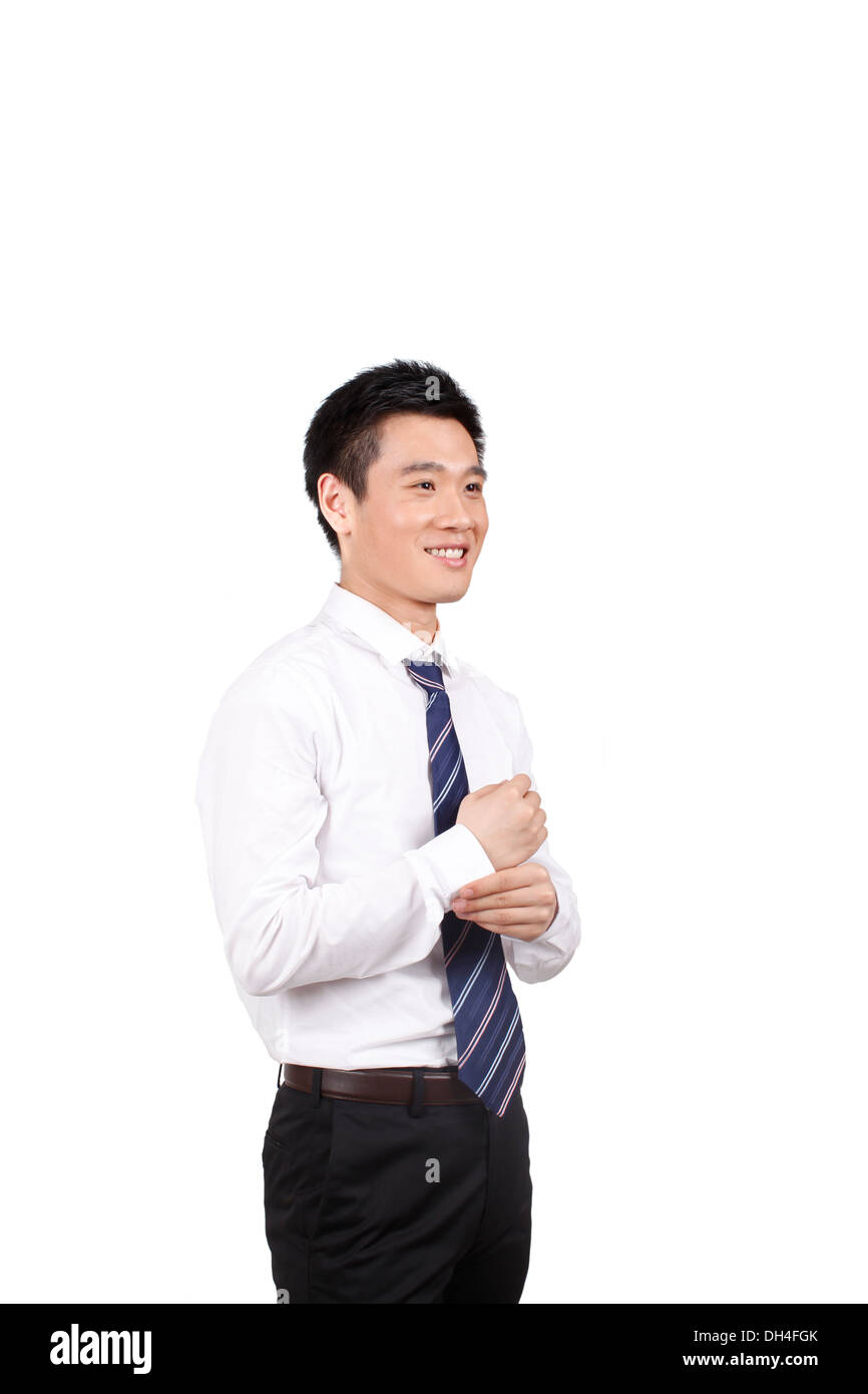 Businessman adjusting tie in room Stock Photo - Alamy