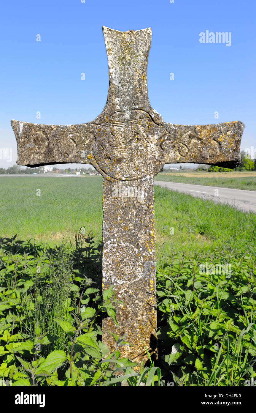 Stone cross on the road Stock Photo
