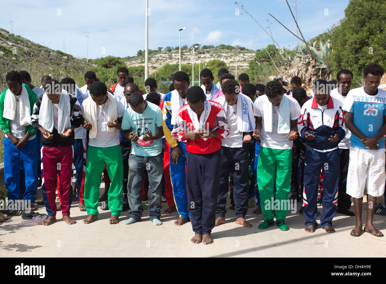 Eritrean migrants rescued from the sea near Lampedusa, Italy gather to prayer for lost relatives during a silent protest. Stock Photo