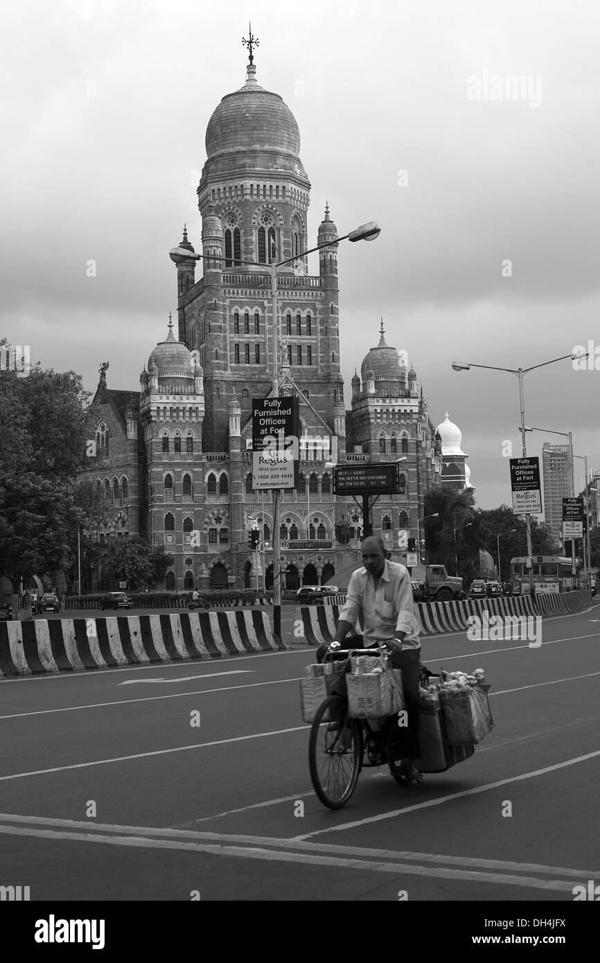 Vendor on bicycle in front of Municipal Corporation Building Mumbai Maharashtra India Asia July 2012 Stock Photo