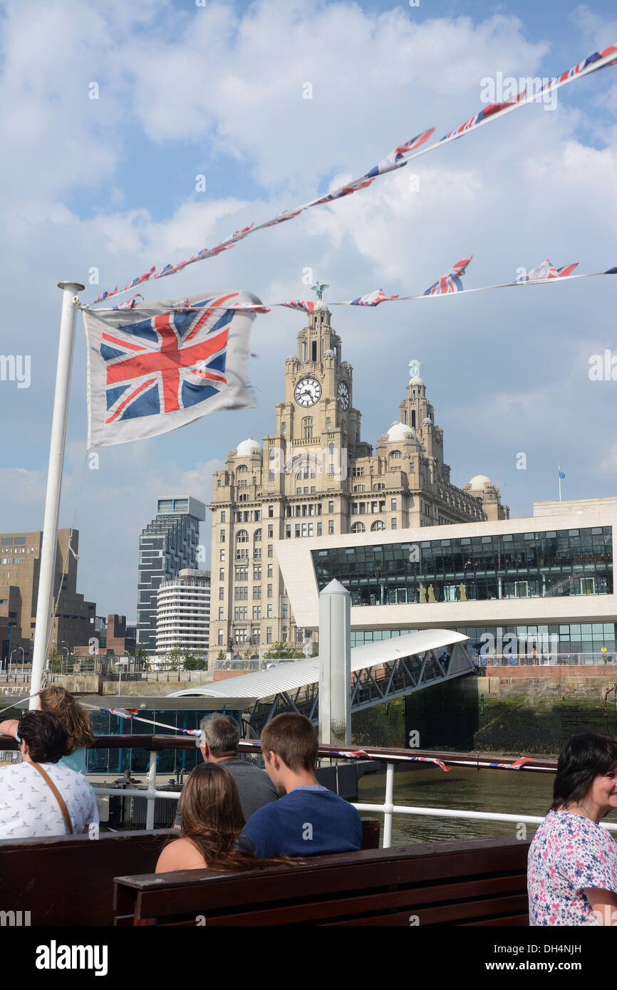 The Royal Liver building seen through flags from a Mersey ferry arriving at the Pier Head. Stock Photo