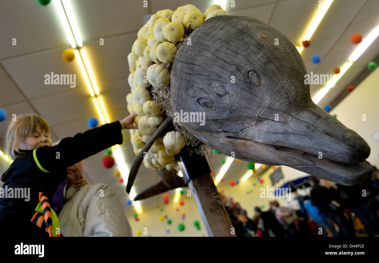 Erfurt, Germany. 31st Oct, 2013. Four year old Chantal plucks a pumpkin from a dolphin figure during the pumpkin slaughter party in the egapark in Erfurt, Germany, 31 October 2013. Egapark visitors can paint the pumpkins during the festival or take them home for food. Photo: Marc Tirl/dpa/Alamy Live News Stock Photo