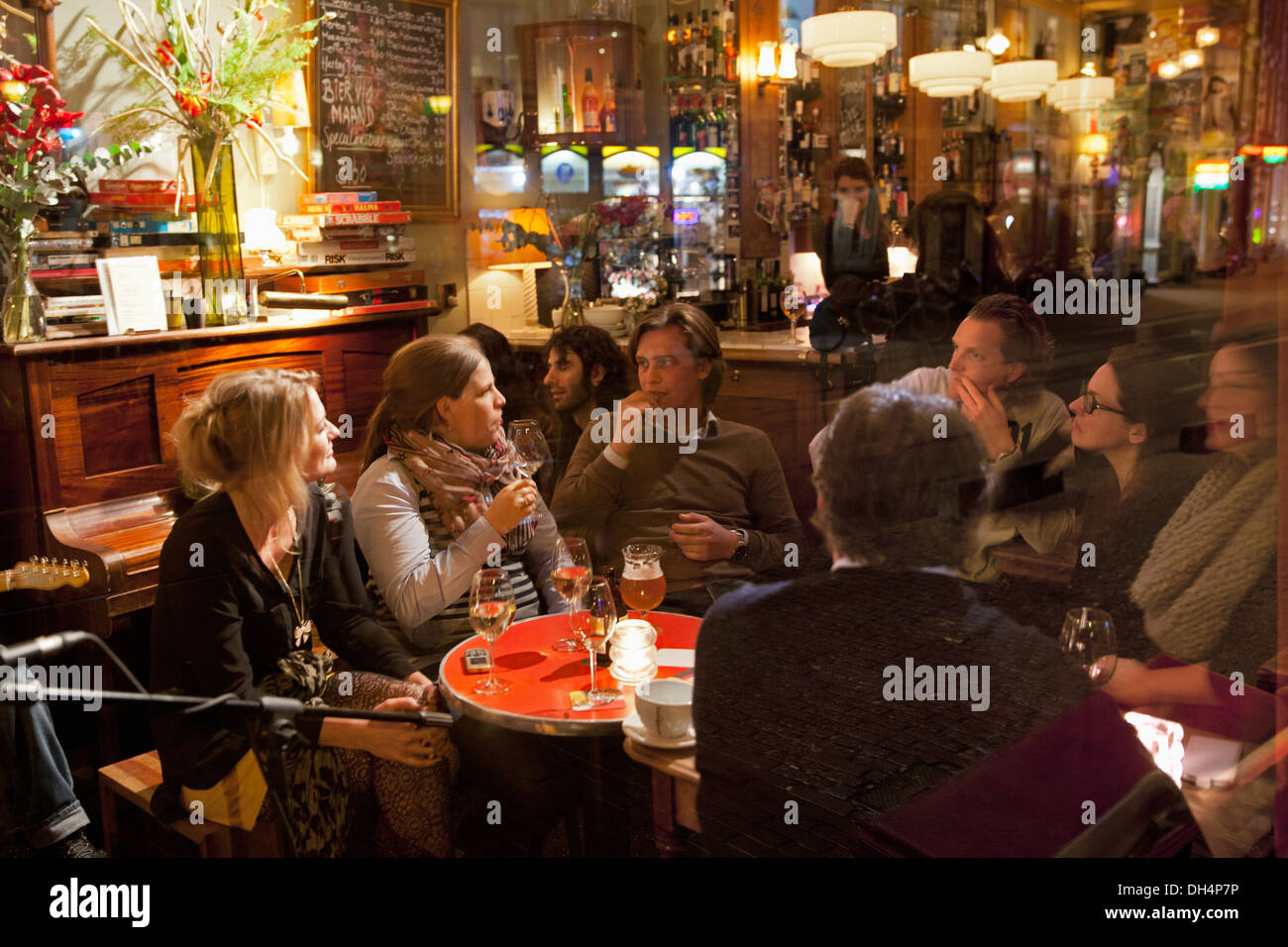 Netherlands, Amsterdam, People chatting and having a drink in brown cafe called Moncafe Stock Photo