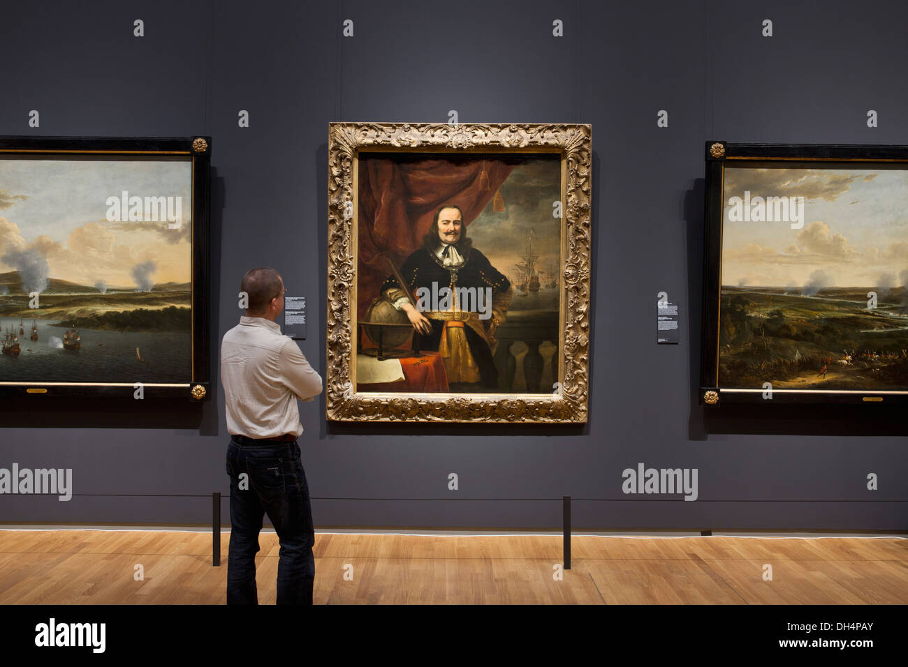 Netherlands, Amsterdam, Rijksmuseum. Visitor looking at painting of Michiel de Ruyter as Lieutenant - Admiral, Ferdinand Bol Stock Photo