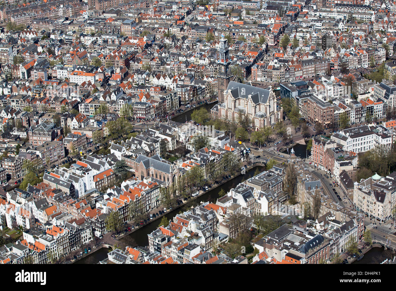 Netherlands, Amsterdam, View on church called Westerkerk, canals and canal houses. Aerial Stock Photo