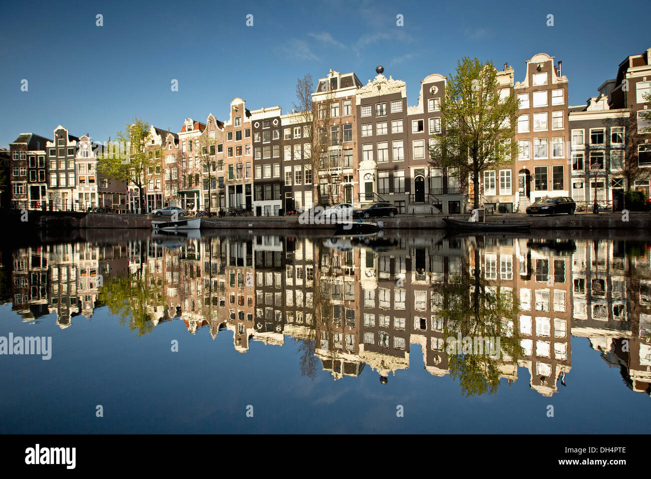 The Netherlands, Amsterdam, Reflection of Canalside houses and houseboats at canal called Singel. Unesco World Heritage Site. Stock Photo