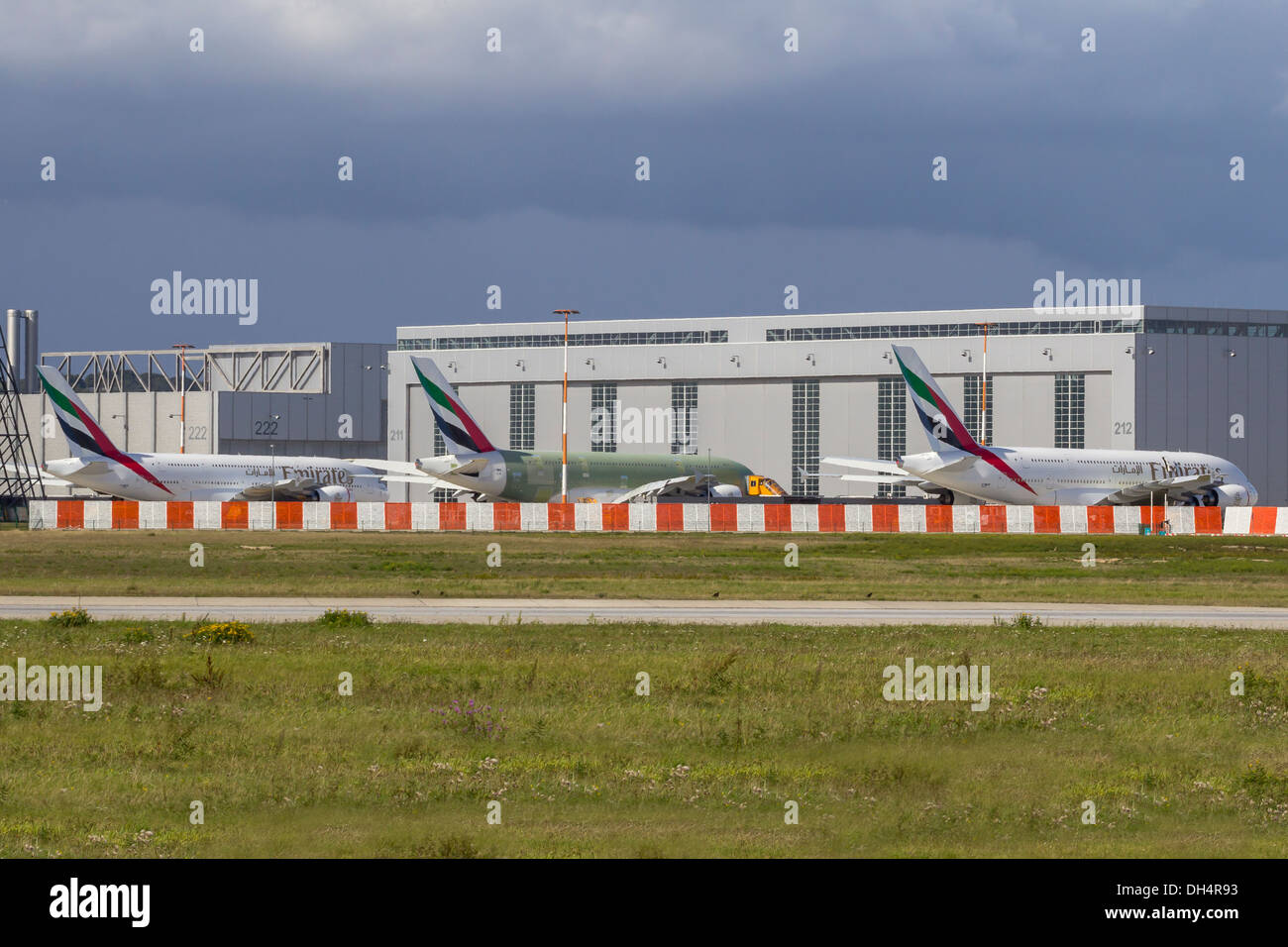 HAMBURG, GERMANY - SEPTEMBER 16, 2013: Lineup of three Emirates Airbus A380 in different development stages on the Airbus Plant Stock Photo