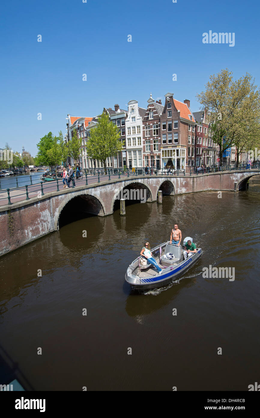 Netherlands, Amsterdam, Crossing of canals called Keizersgracht and Leidsegracht. UNESCO World heritage Site. Small boat Stock Photo