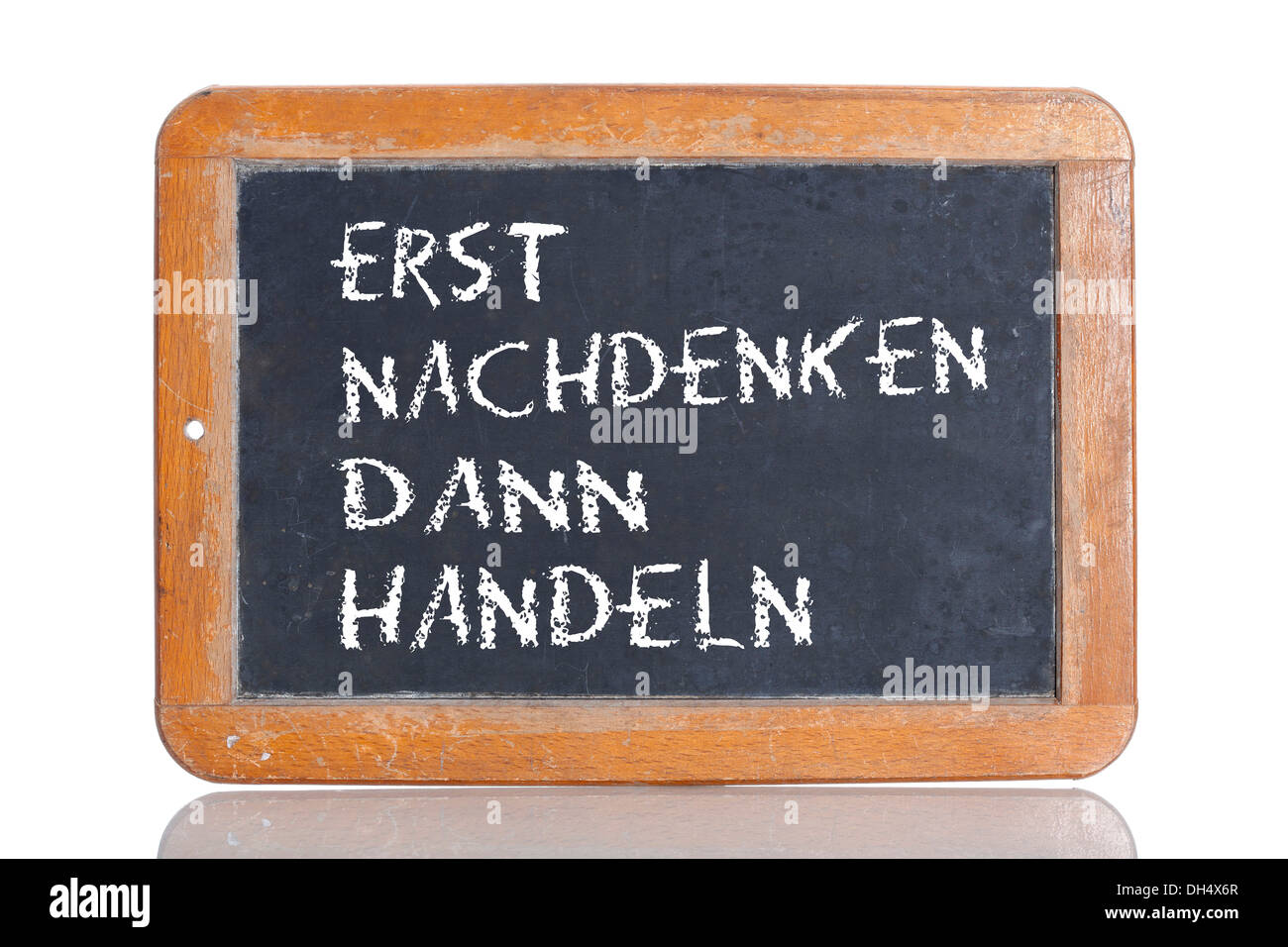 Old school blackboard with the phrase ERST NACHDENKEN DANN HANDELN, German for Think first, then act Stock Photo