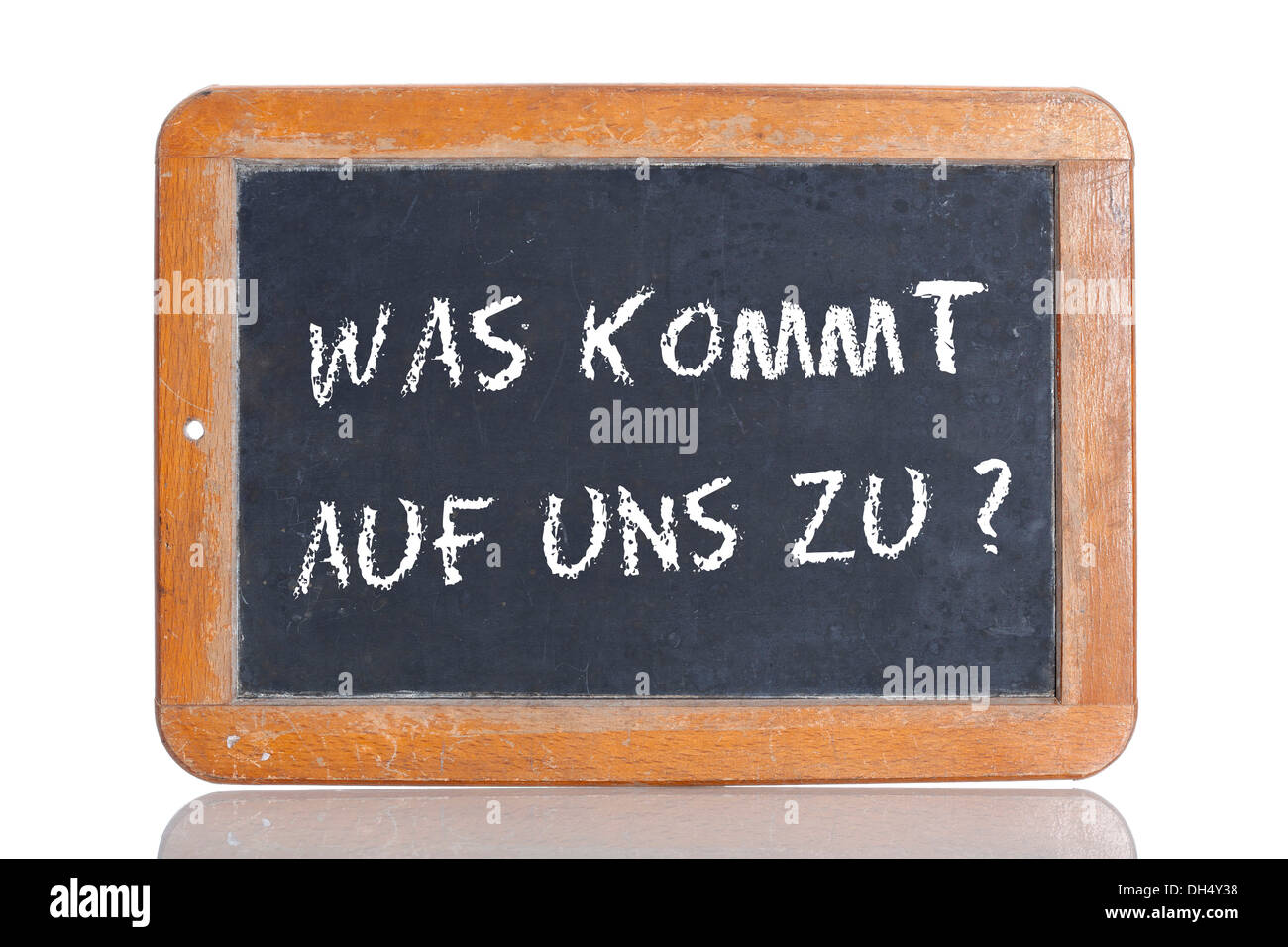 Old school blackboard with the words WAS KOMMT AUF UNS ZU?, German for What's in store for us? Stock Photo