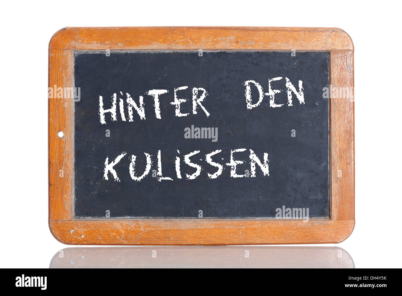 Old school blackboard with the term HINTER DEN KULISSEN, German for behind the scenes Stock Photo