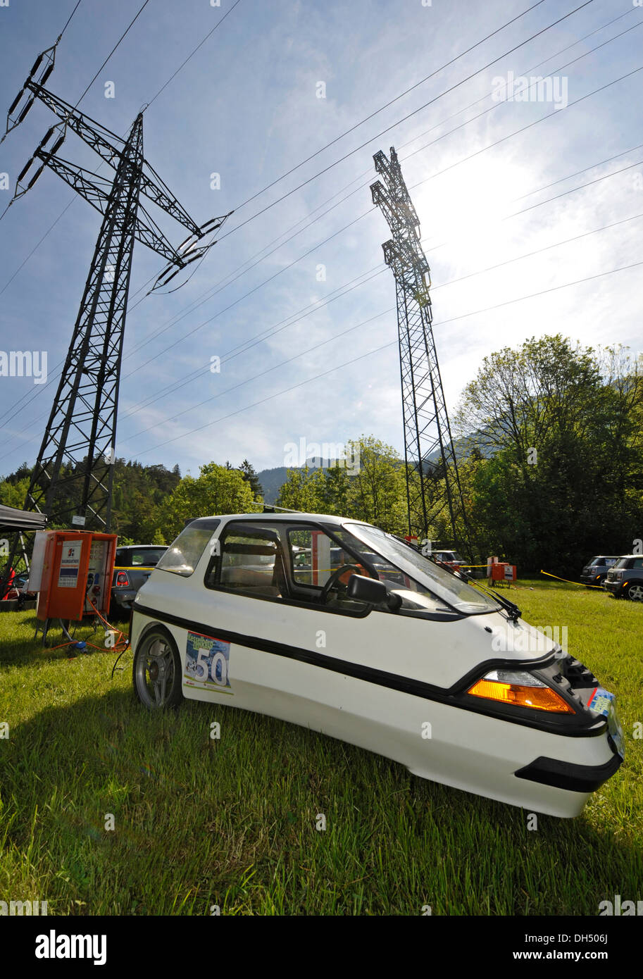 Electric car on a lawn in front of power poles, Kesselbergrennen race