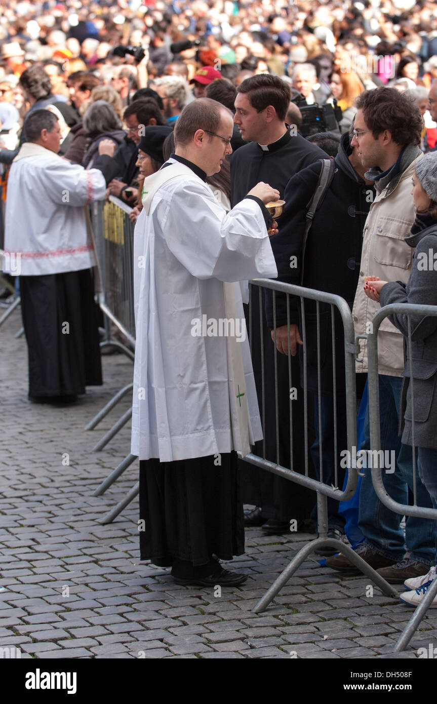 Priest give communion to faithful Stock Photo