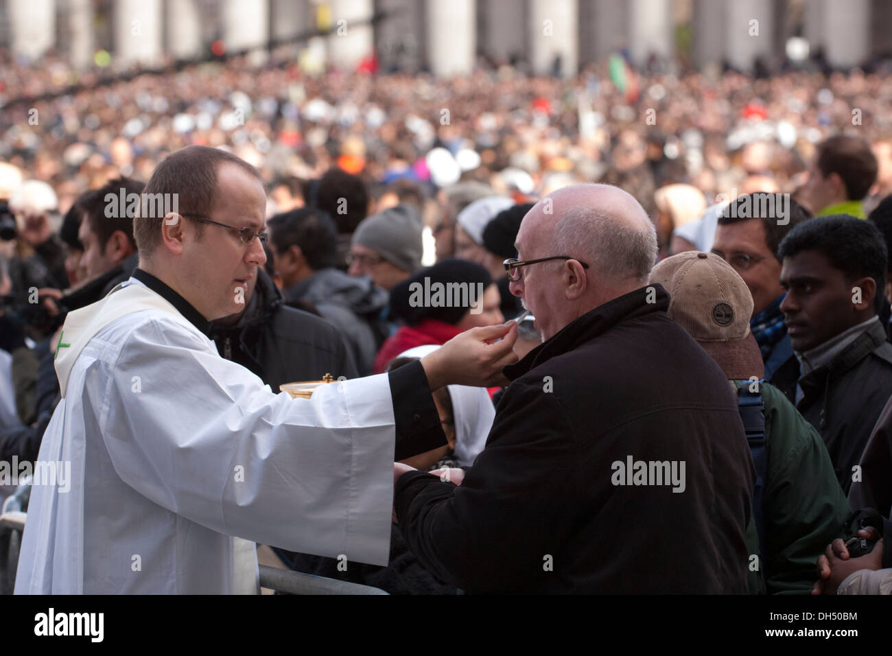 Priest give communion to faithful Stock Photo