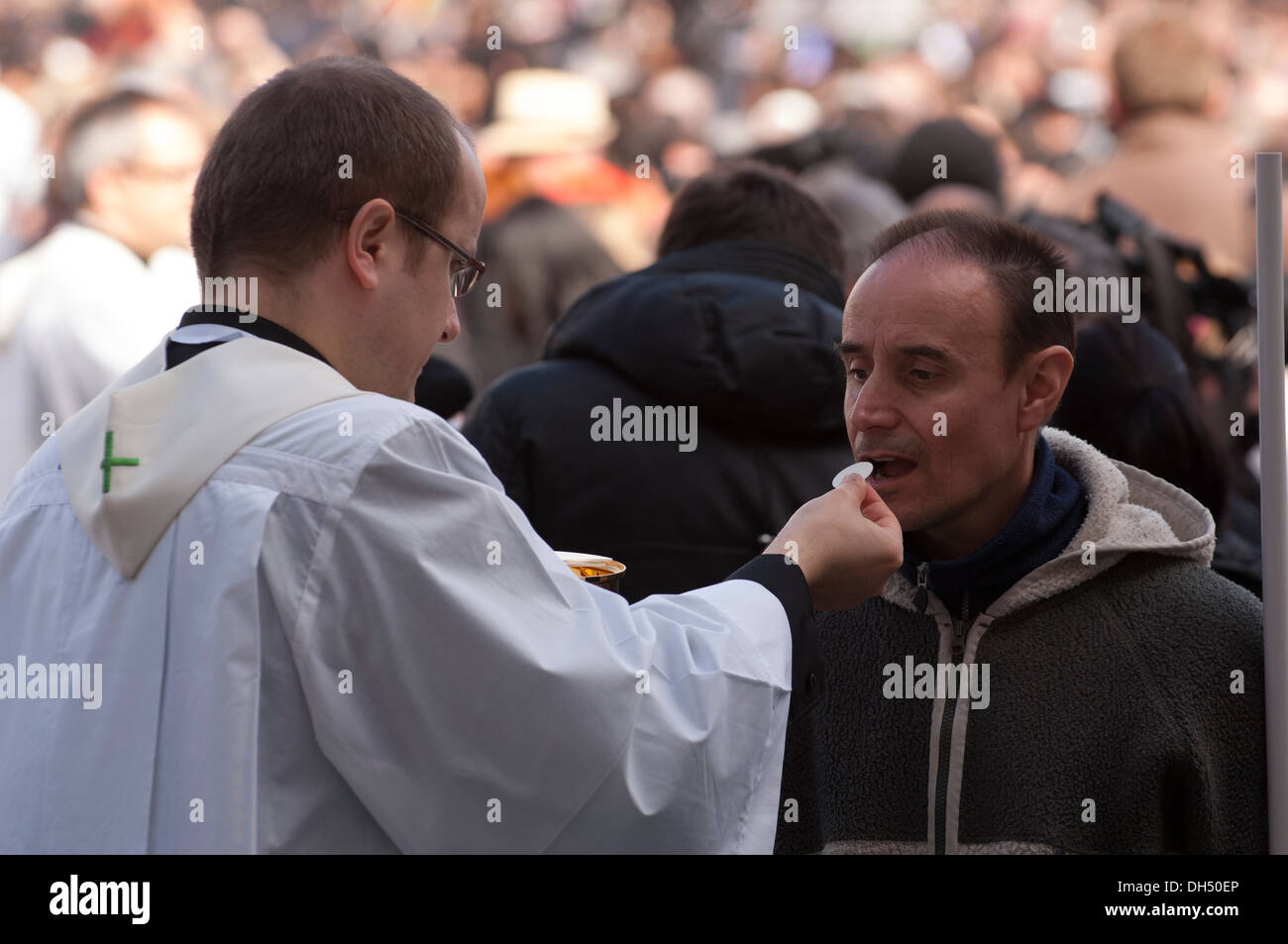 Priest give communion to faithful Stock Photo