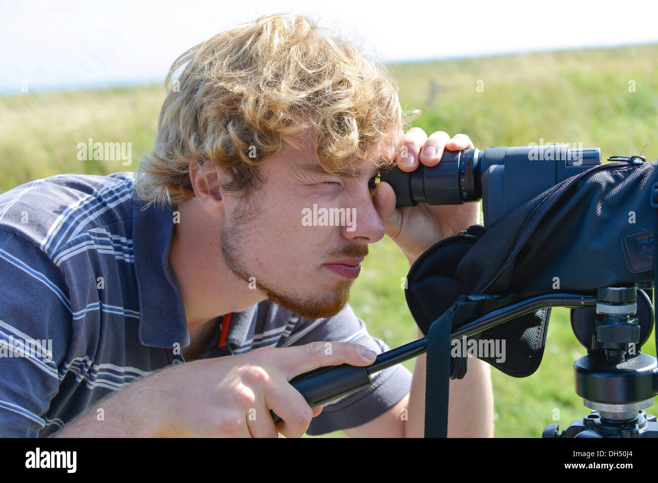 Young man watching something with a spotting scope Stock Photo