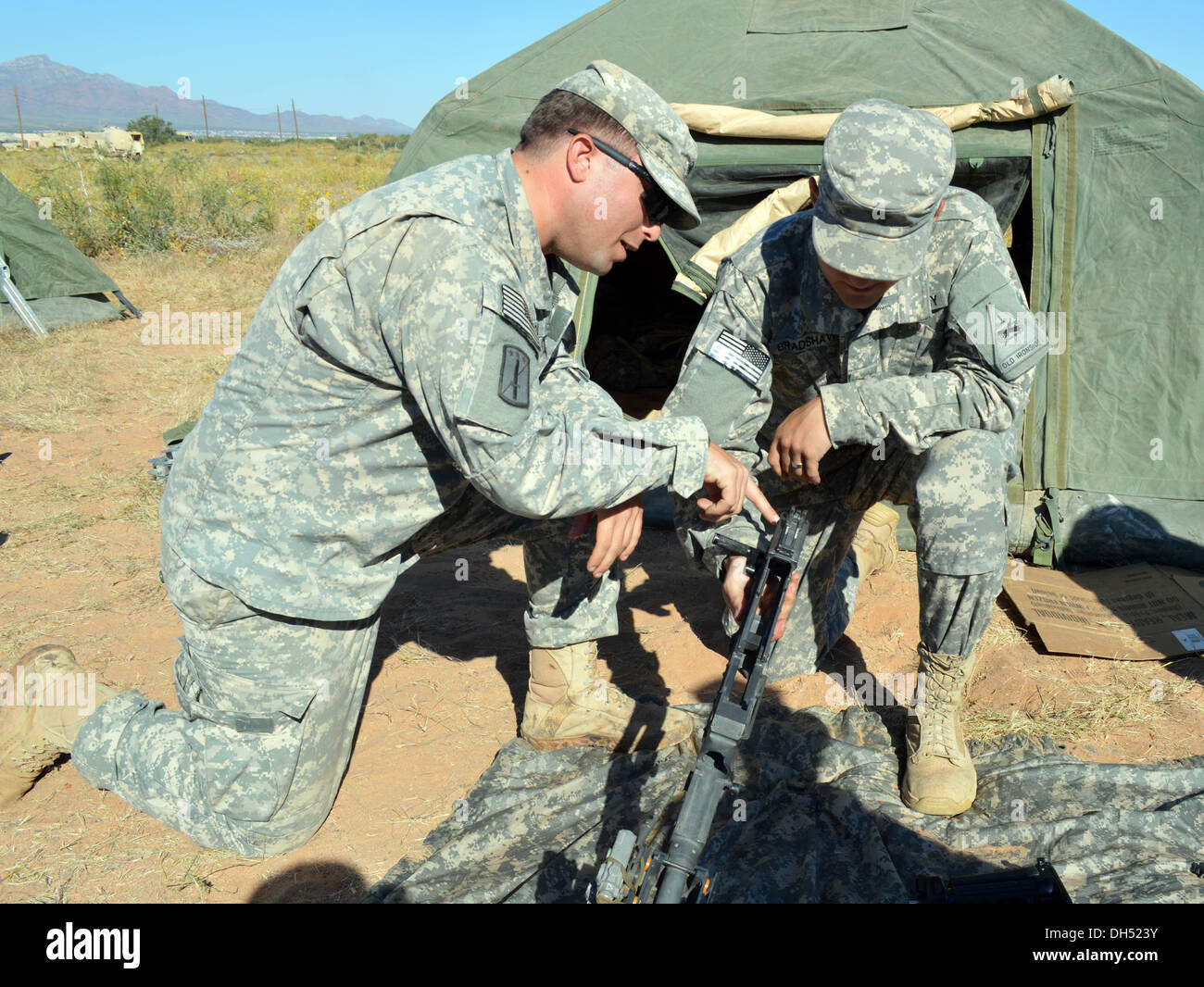 Sgt. Ian Bowman, a squad leader in Alpha Company, 1st Battalion, 6th Infantry Regiment, 2nd Brigade, 1st Armored Division, instructs Pvt. Austin Bradshaw, a saw gunner for A Co., 1-6IN, 2/1AD, on assembling a M240B at Fort Bliss, Texas, Oct. 25, 2013. Sol Stock Photo