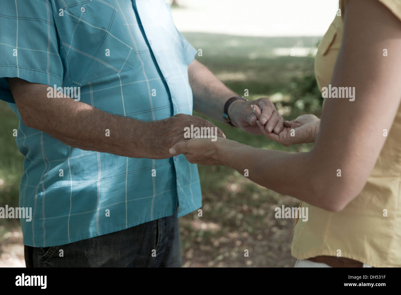 A Woman and an elderly man holding each other hands Stock Photo