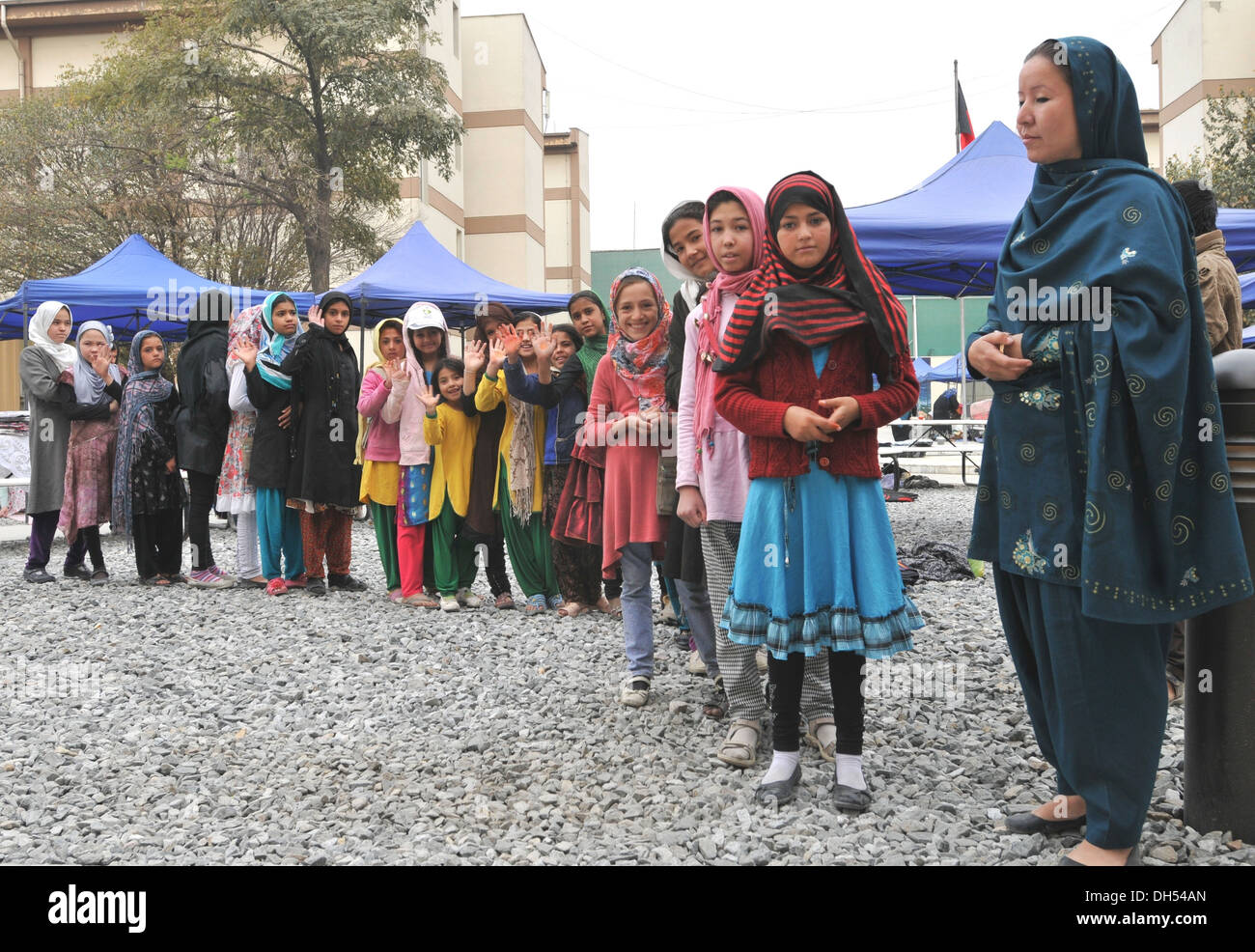Children line up to get school supplies, toys, and sundries handed out by the soldiers, contractors and civilians at the Afghan Stock Photo