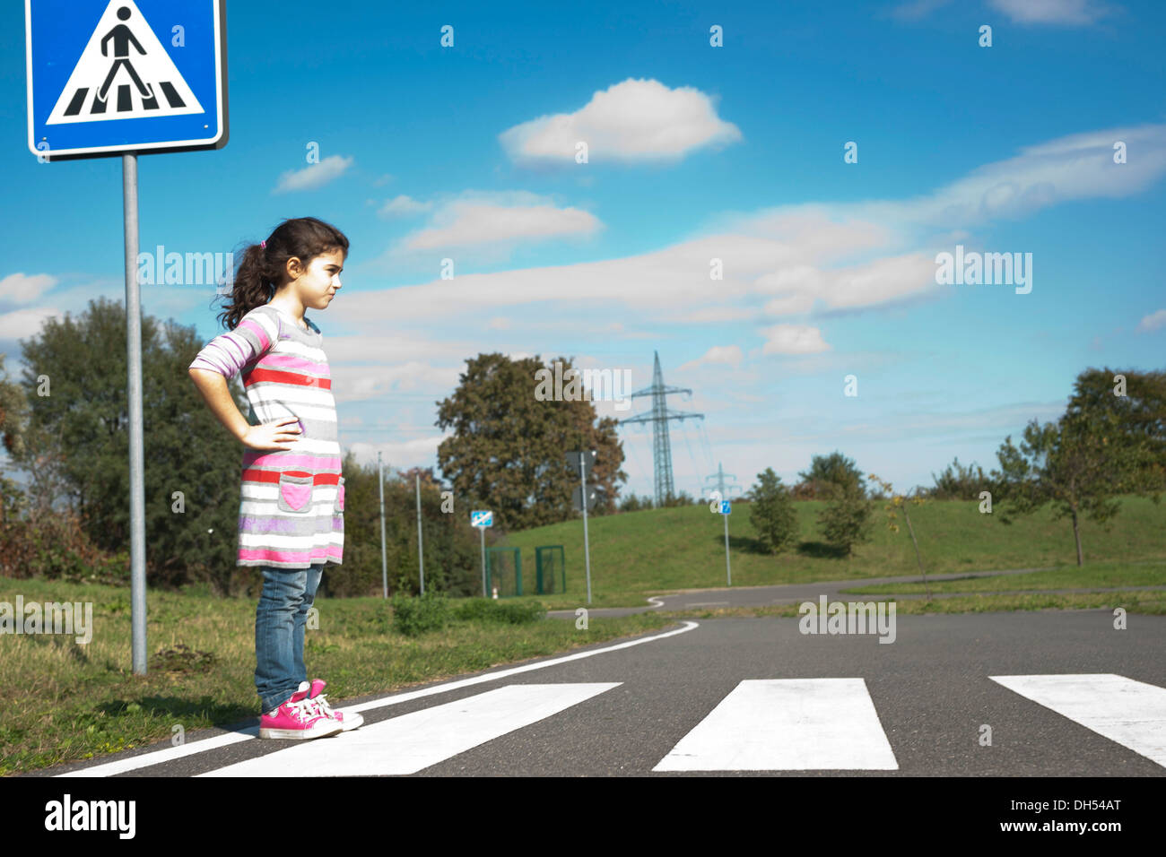 Girl waiting at a zebra crossing Stock Photo