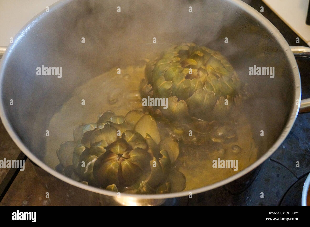 Boil  artichoke in water Stock Photo
