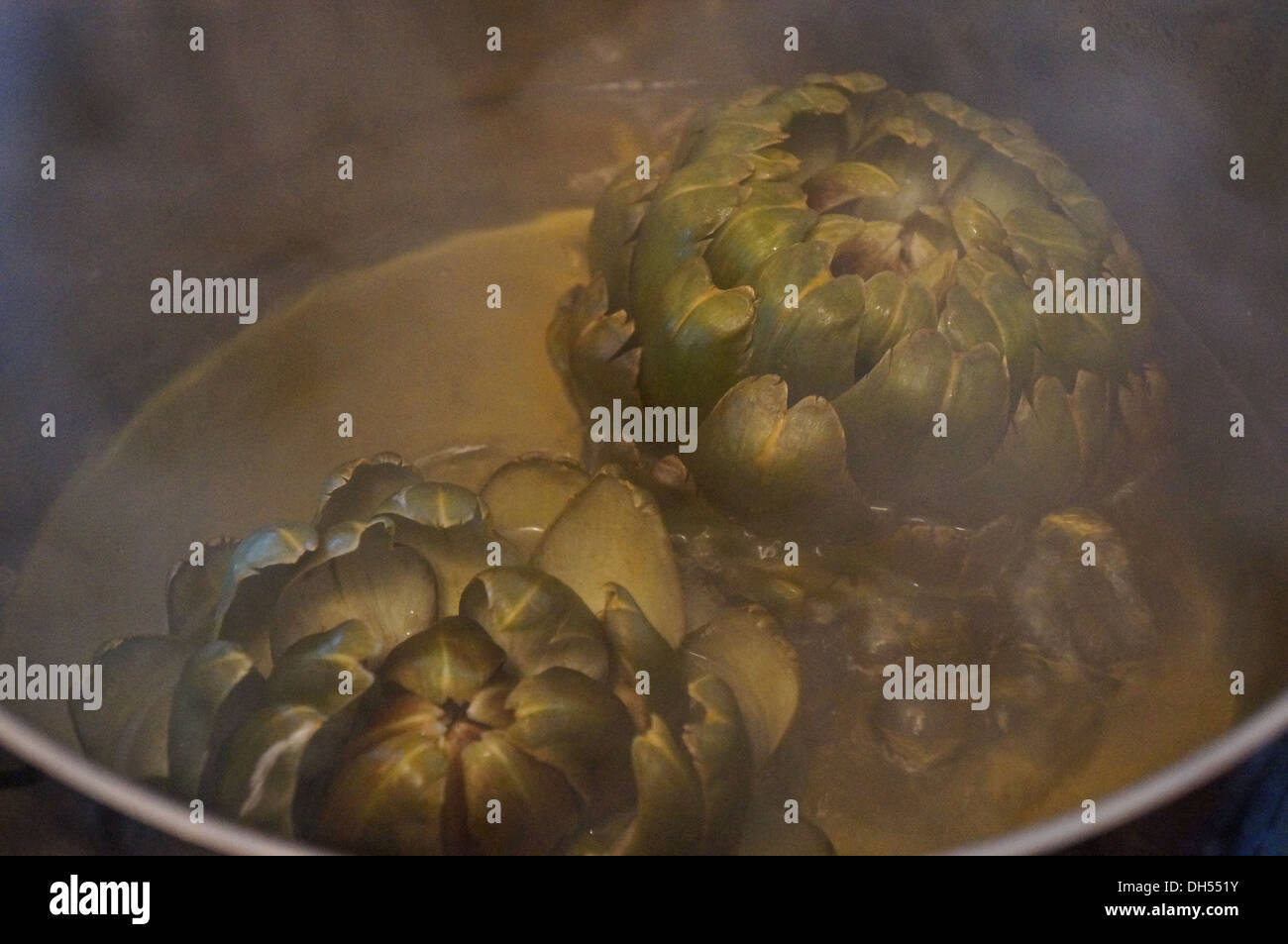 Boil  artichoke in water Stock Photo