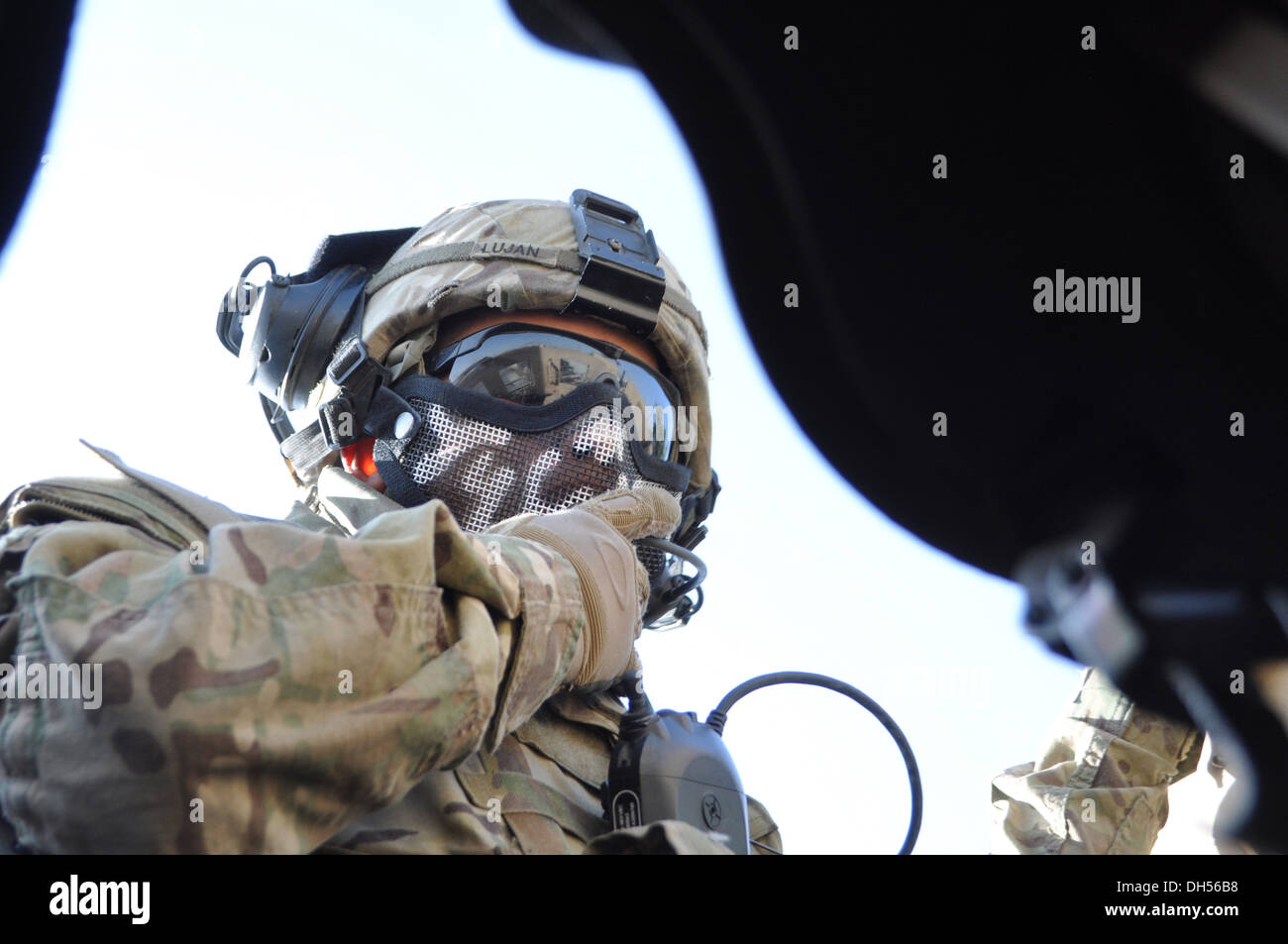 MASKED MASTER -- Spc. Justin E. Lujan, a gunner with Headquarters Company, 1st Battalion, 294th Infantry Regiment, Guam Army National Guard, checks his microphone while standing on a gunner's turret late October during a mission to Camp Eggers, Kabul, Afg Stock Photo