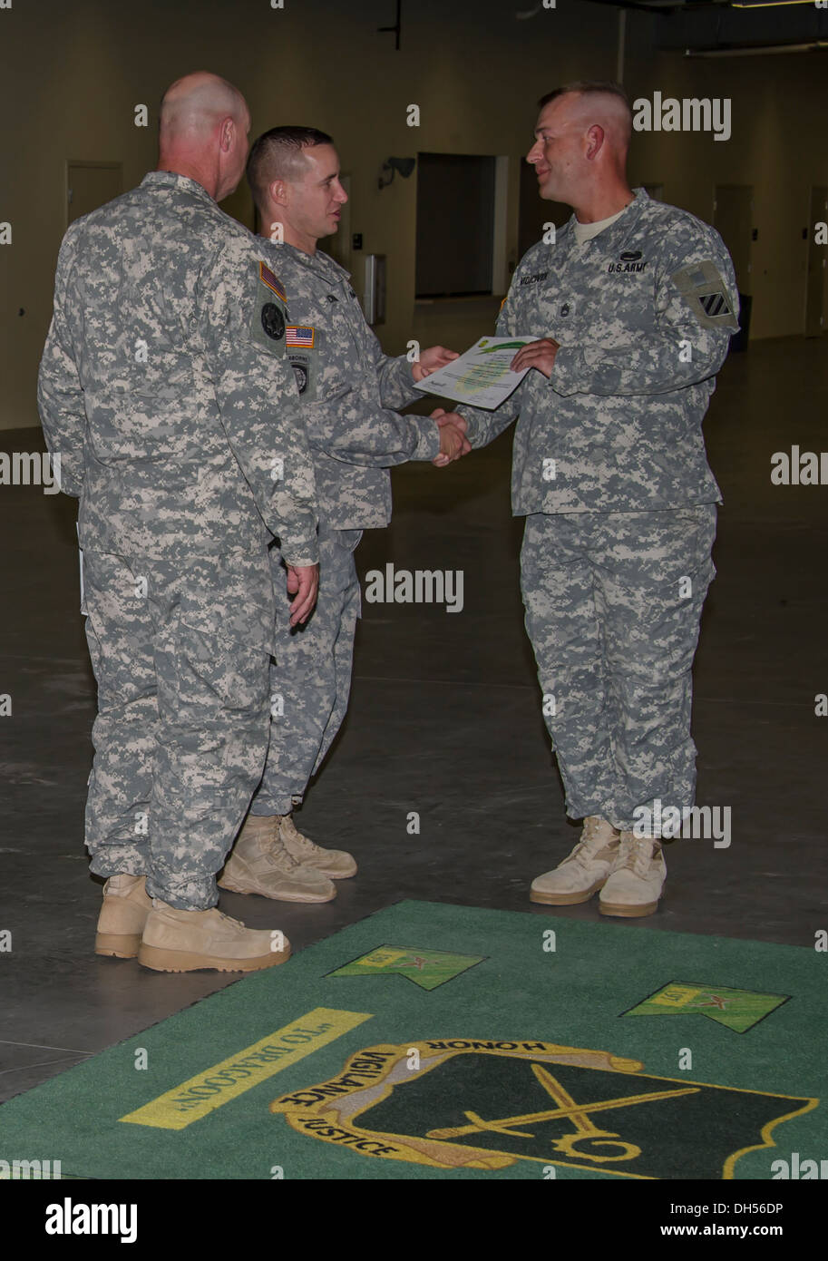 Lt. Col. Jerry Chandler Jr., commander, 385th Military Police Battalion, awards a certificate of completion to Sgt. 1st Class Benjamin Vidacovich, a platoon sergeant with the 2-3 Brigade Special Troops Battalion 'Titans,' 2nd Armored Brigade Combat Team, Stock Photo