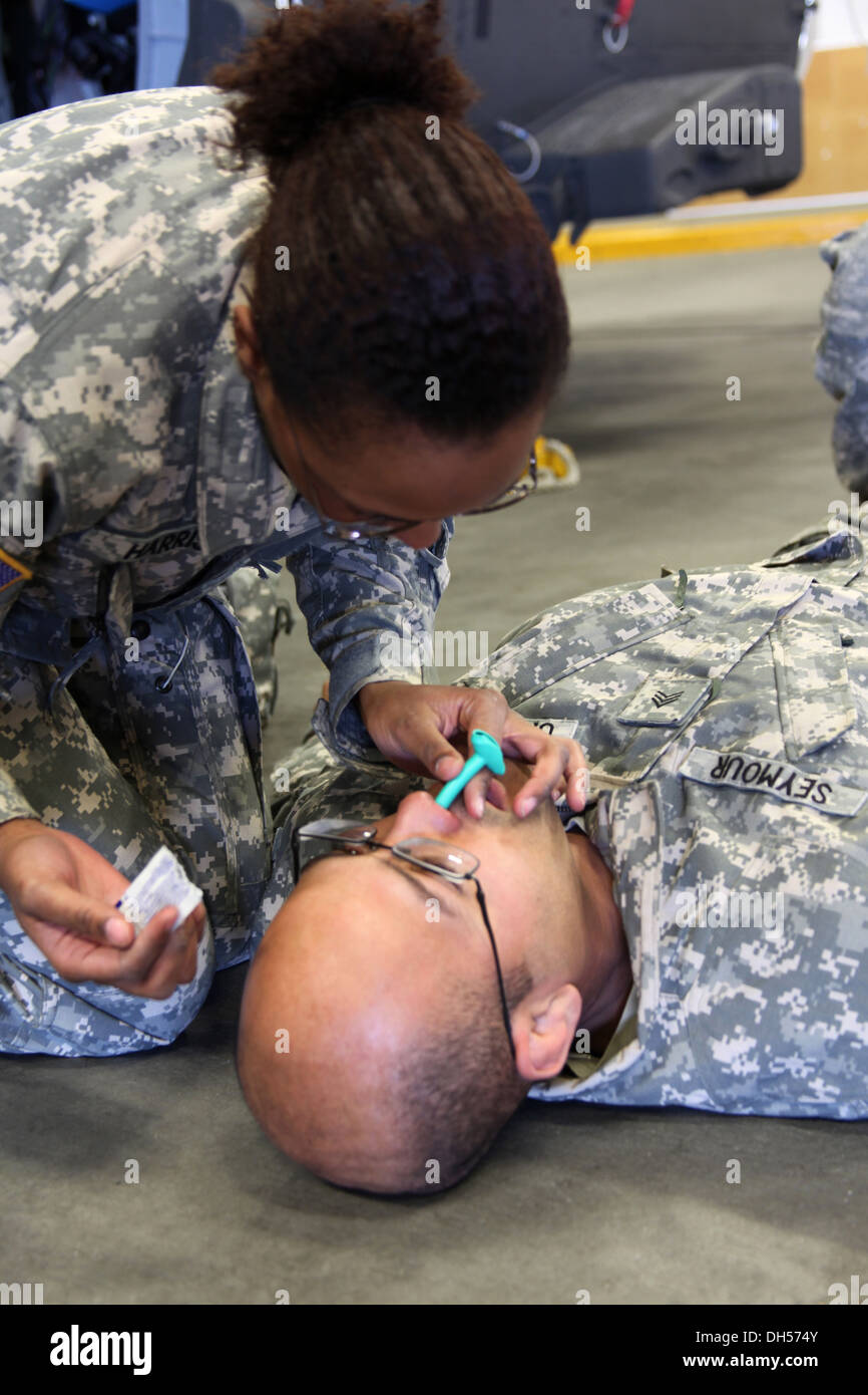 Pfc. Stevie Harris, 2-158th Assault Helicopter Battalion medic, demonstrates how to use a nasopharyngeal airway on Sgt. Donald Seymour, 2-158th AHB crew chief. during first aid training at the Gowen Field Air National Guard Base in Idaho Oct. 22 in suppor Stock Photo