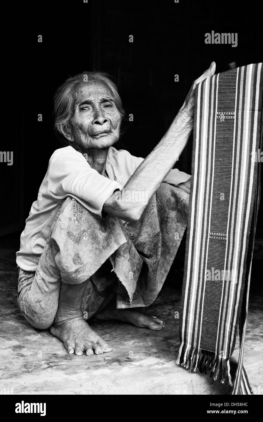 Elderly Indonesian woman selling fabrics, Terara, Lombok island, Nusa Tenggara Barat Province, Indonesia Stock Photo