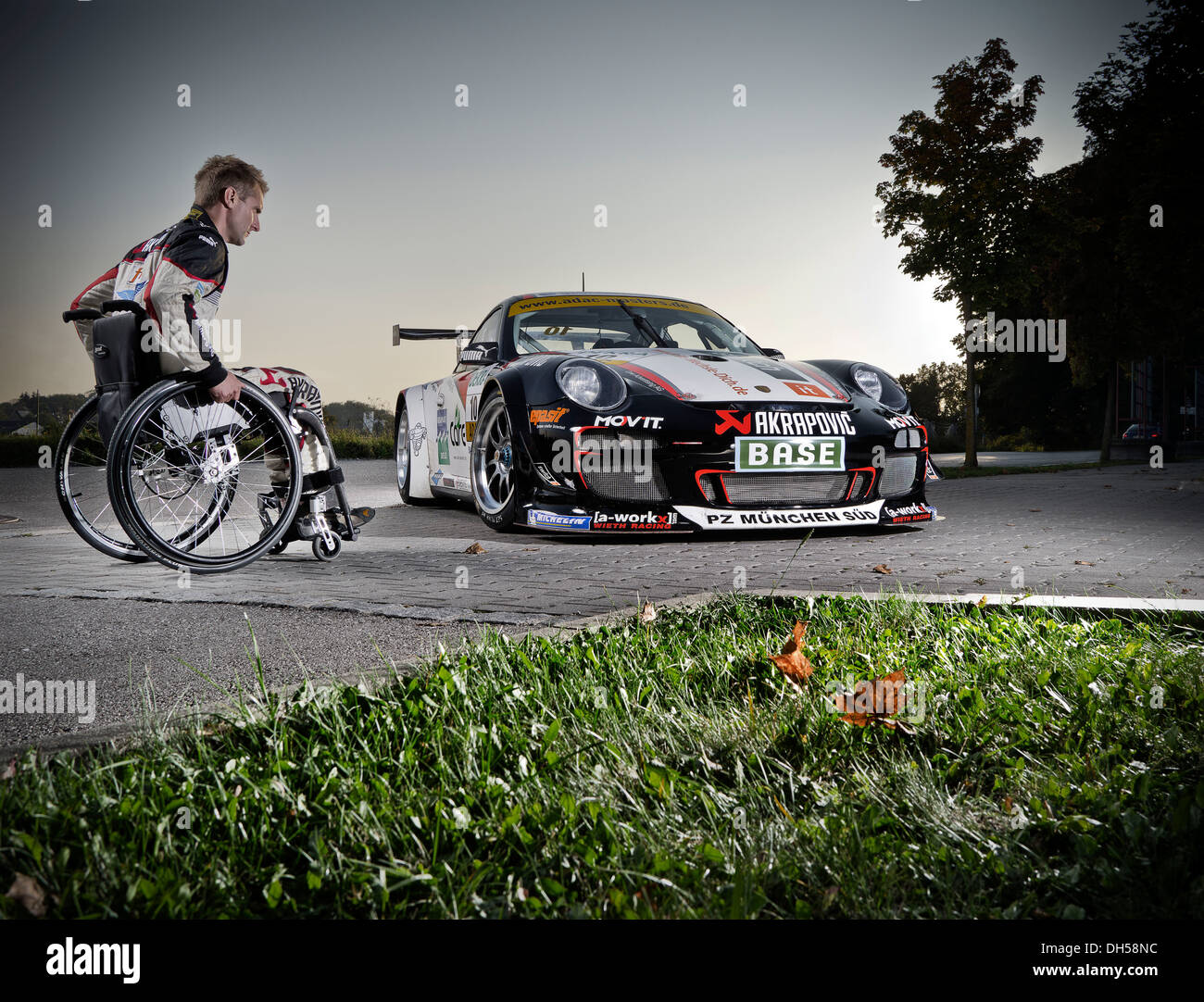 Race car driver in a wheelchair, next to his Porsche race car, Munich