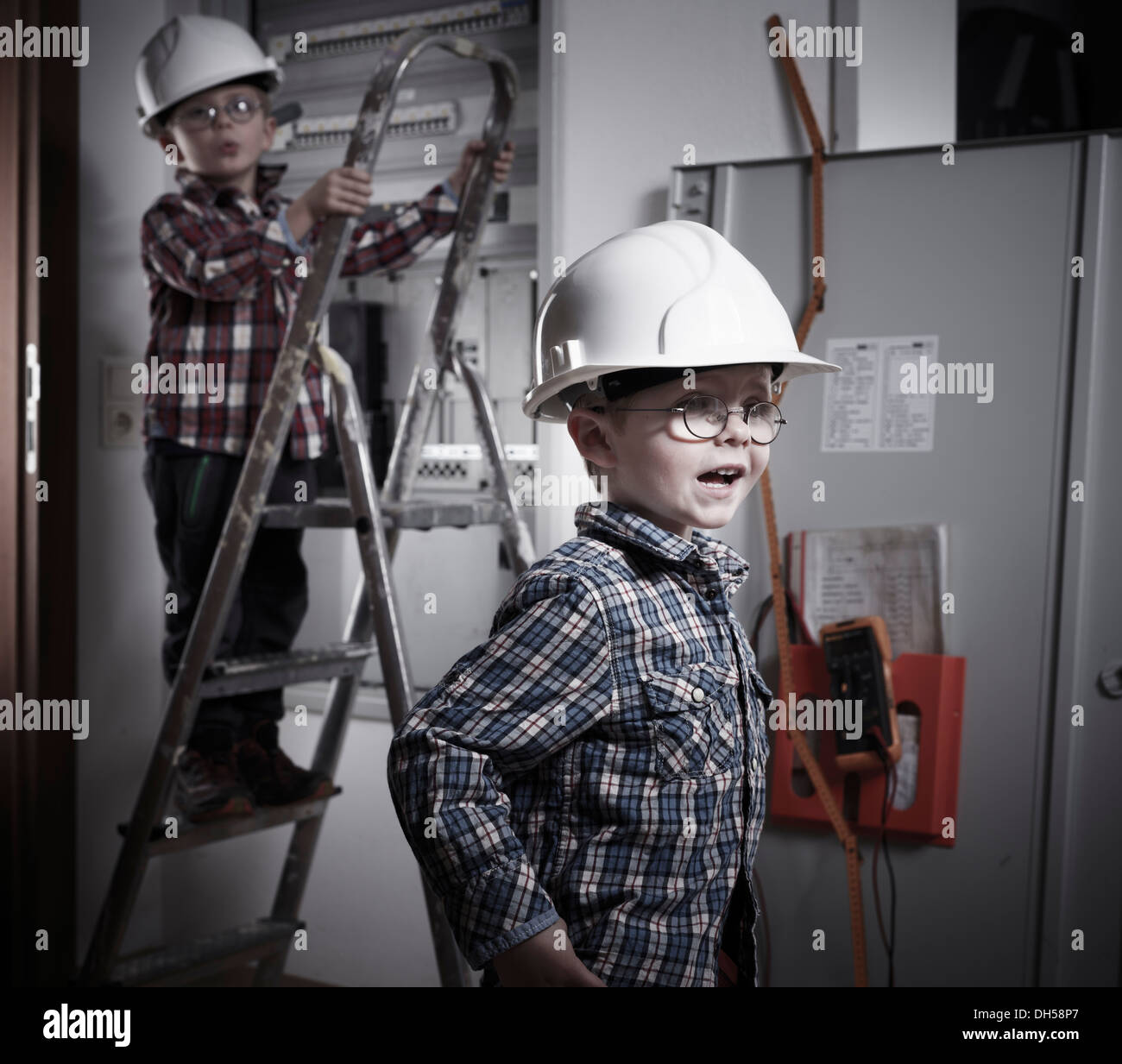 Two boys wearing helmets playing construction workers, Kolsass, Tyrolean Unterland, Tyrol, Austria Stock Photo