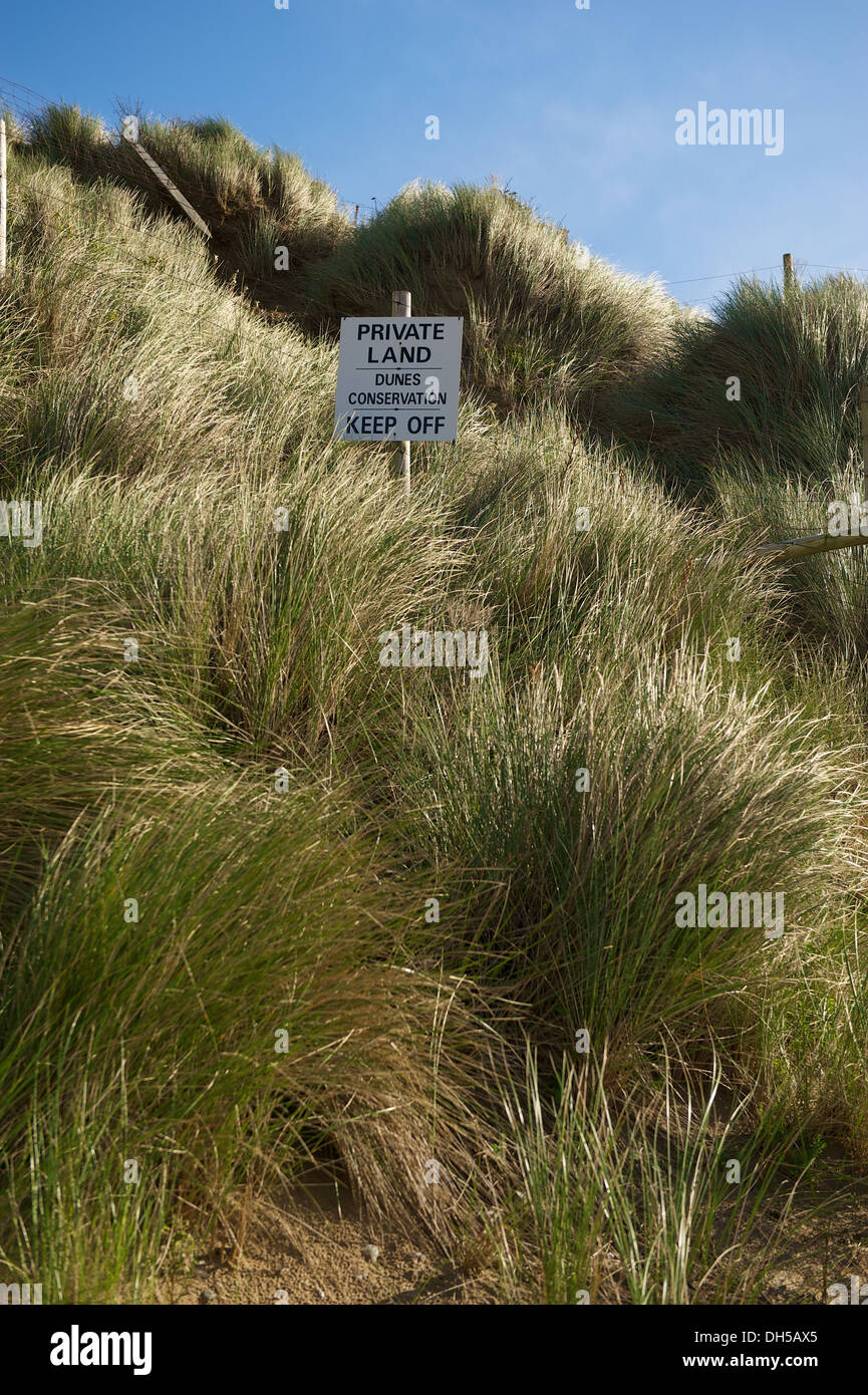 Beach sand dune grass at Mawgan Porth beach in Cornwall with a Private Land sign, saying Keep off Stock Photo