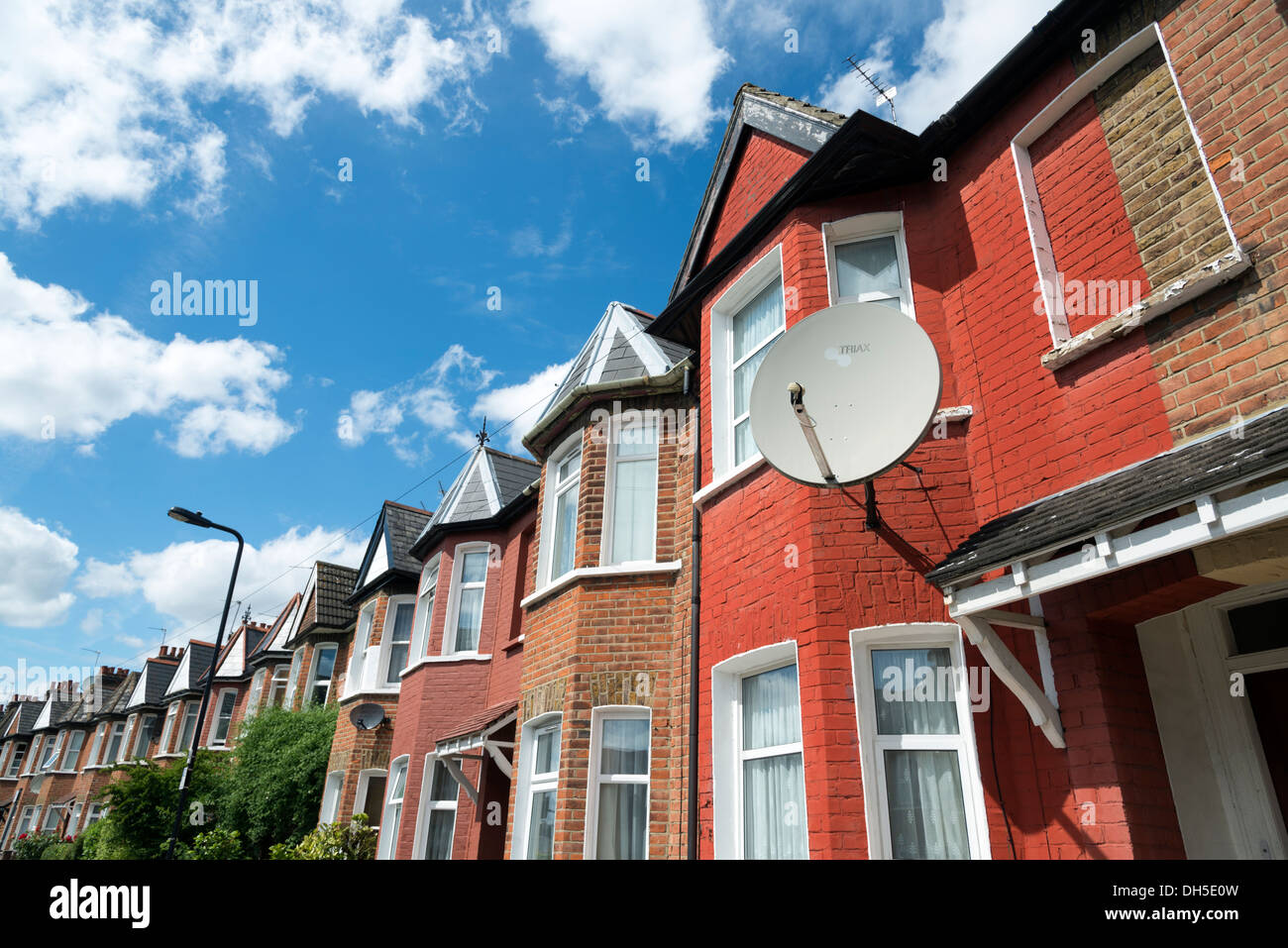 Satellite dish on a terraced house on a residential street, London, England, UK Stock Photo