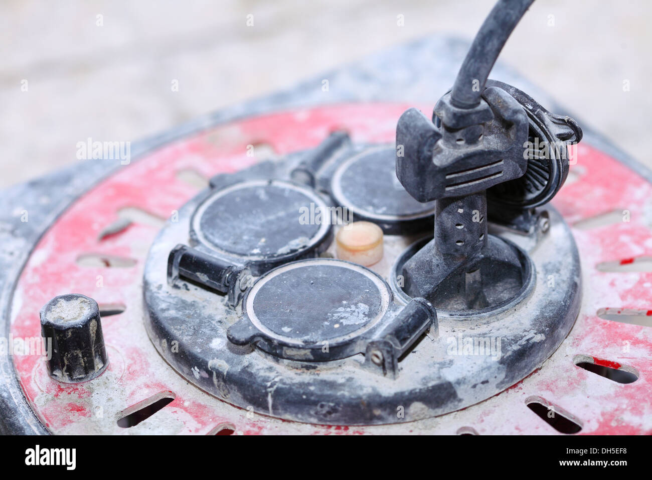Close up old dirty extension electric cable cord reel on construction