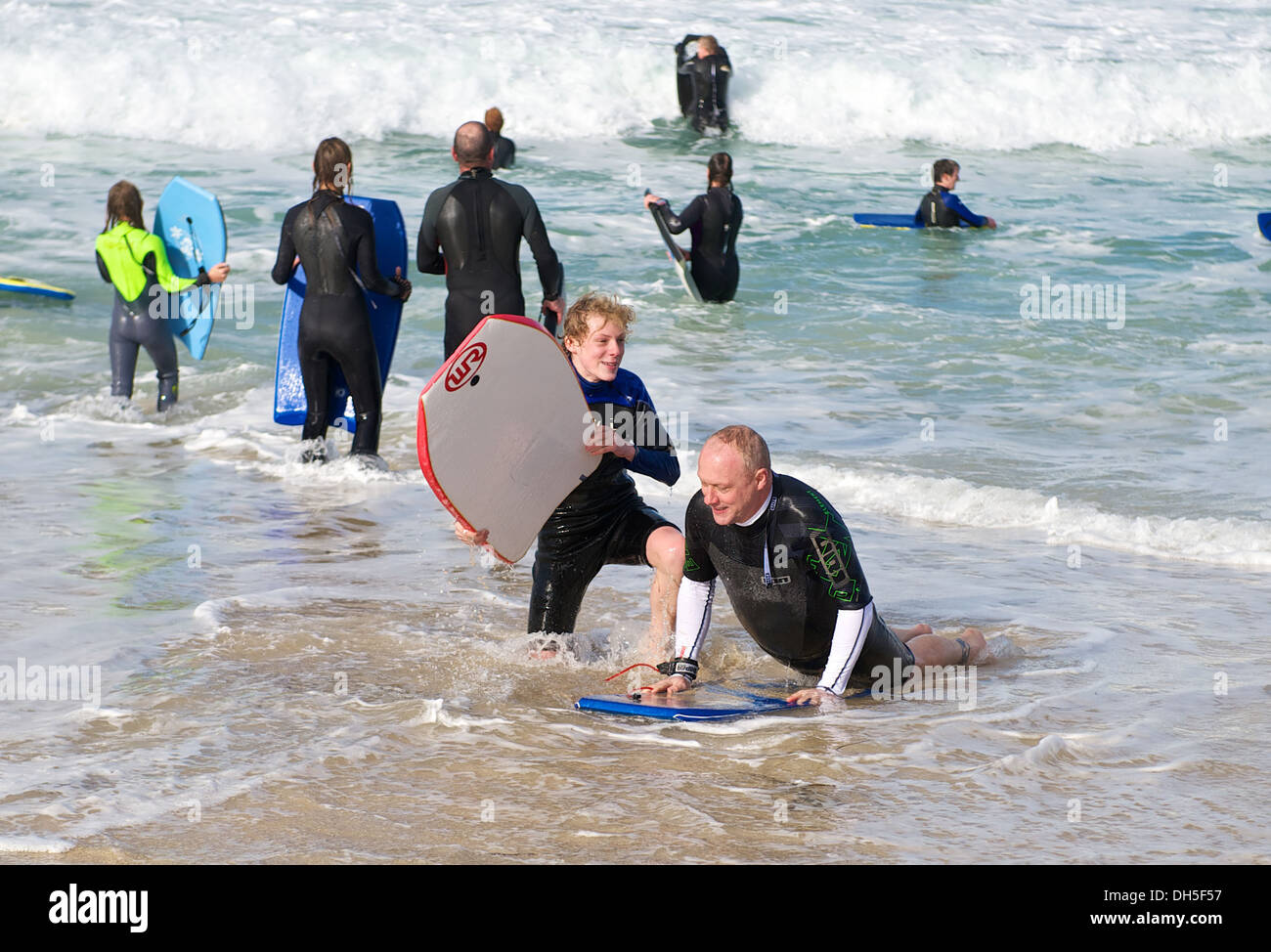 Father and son body board surfing in the sea on the beach in St. Ives Cornwall England UK Stock Photo