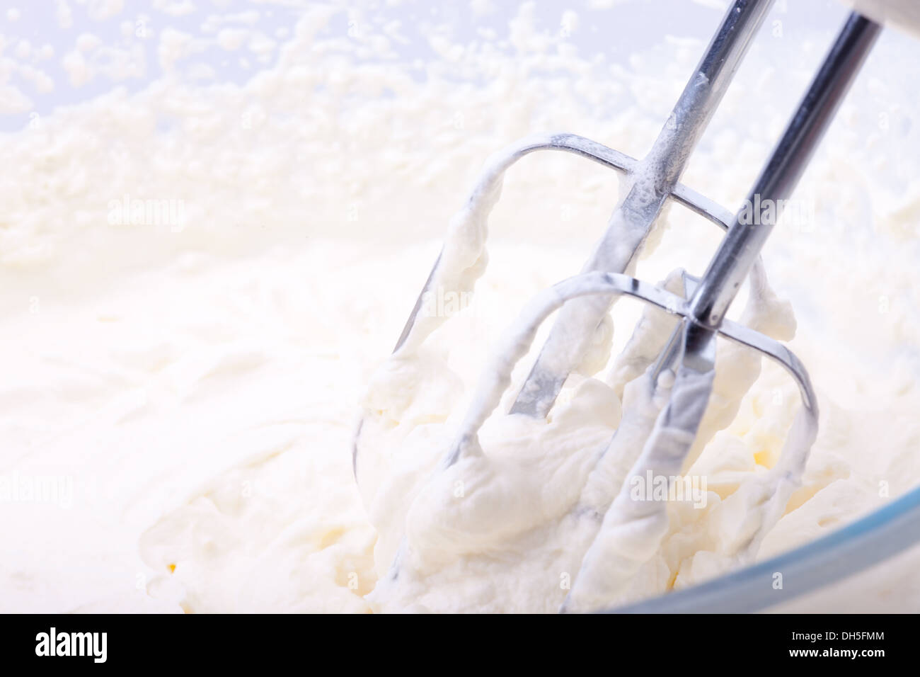 Whipping cream (double cream) being beaten with a whisk in a glass bowl Stock Photo Alamy