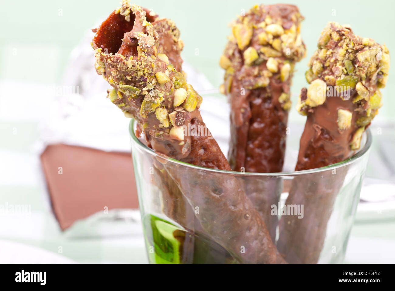 brandy snaps dipped in chocolate and pistachios Stock Photo