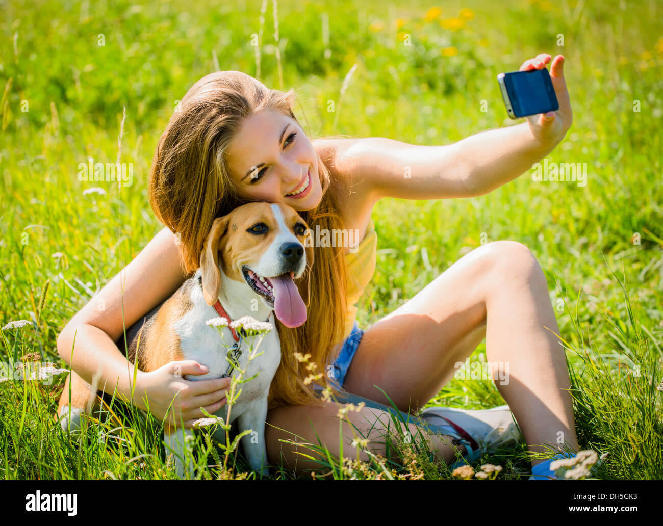 Teen girl taking photo of herself and her dog with mobile phone camera Stock  Photo - Alamy