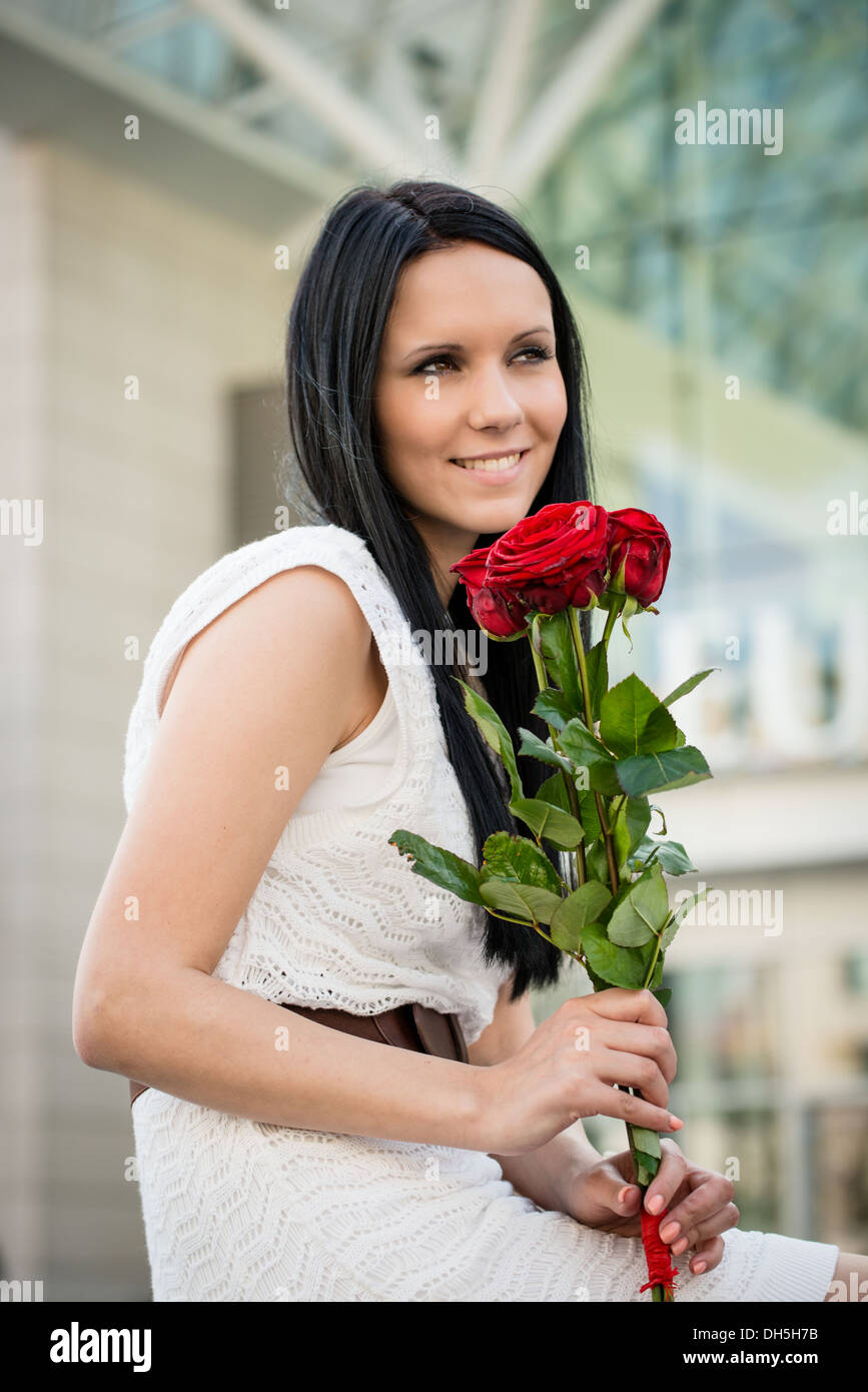 Young beautiful woman with red roses - outdoorf lifestyle portrait Stock Photo